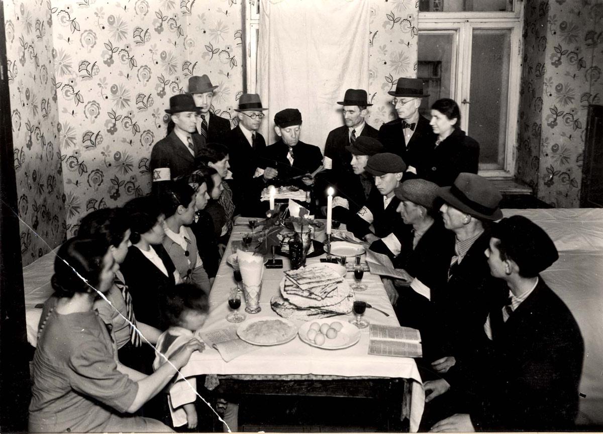 Warsaw, Poland, Jews around a seder table in a shelter on 6 Leszno St. in the ghetto, reading from the Passover Haggada Warsaw, Poland, Jews around a seder table in a shelter on 6 Leszno St. in the ghetto, reading from the Passover Haggada